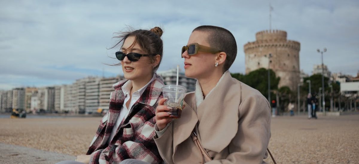 Stylish young women enjoy a day by the iconic White Tower in Thessaloniki, Greece.